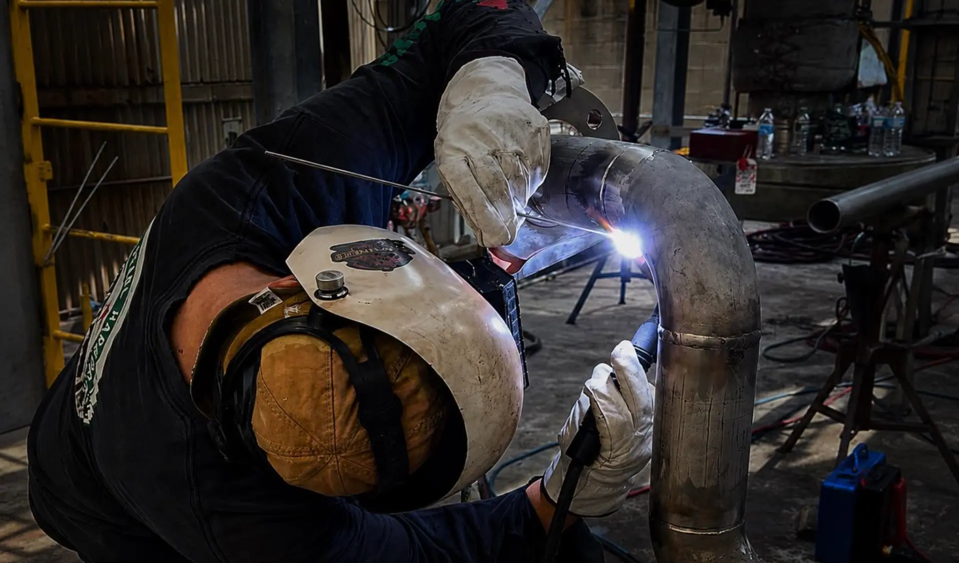 Certified welder TIG welding a stainless steel pipe elbow